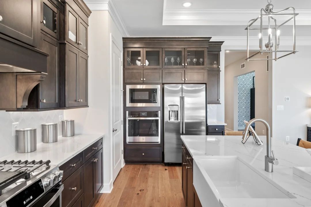 Kitchen with island, pendant lighting and glass-front upper cabinets