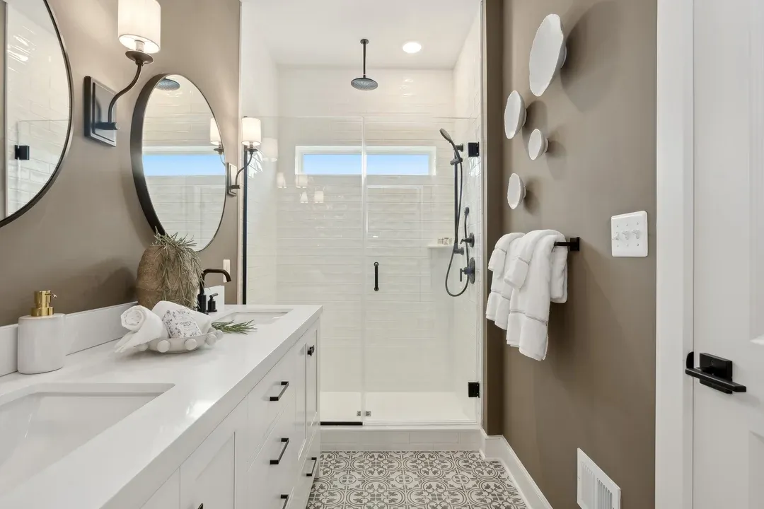 Primary bath with dual sinks and glass shower enclosure