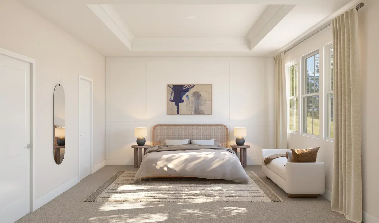 Primary suite with tray ceiling, crown moulding and decorative feature wall
