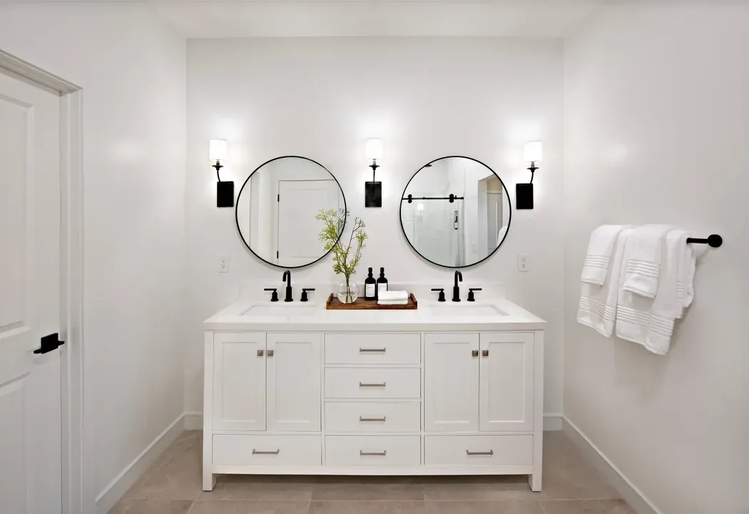 Primary bath with freestanding vanity and circular mirrors