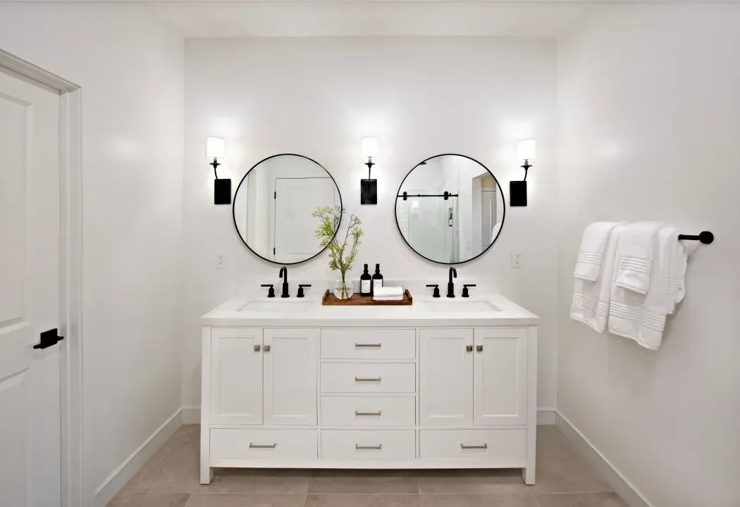 Primary bath with freestanding vanity and circular mirrors