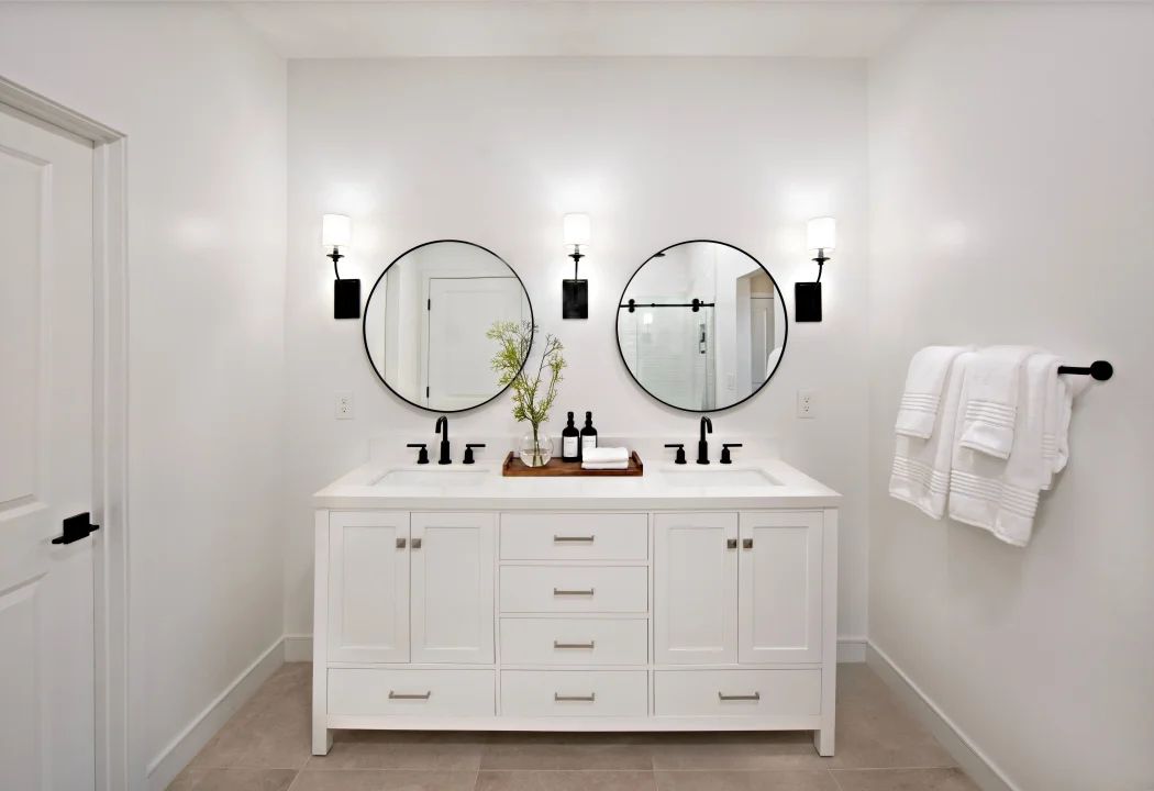 Primary bath with freestanding vanity and circular mirrors