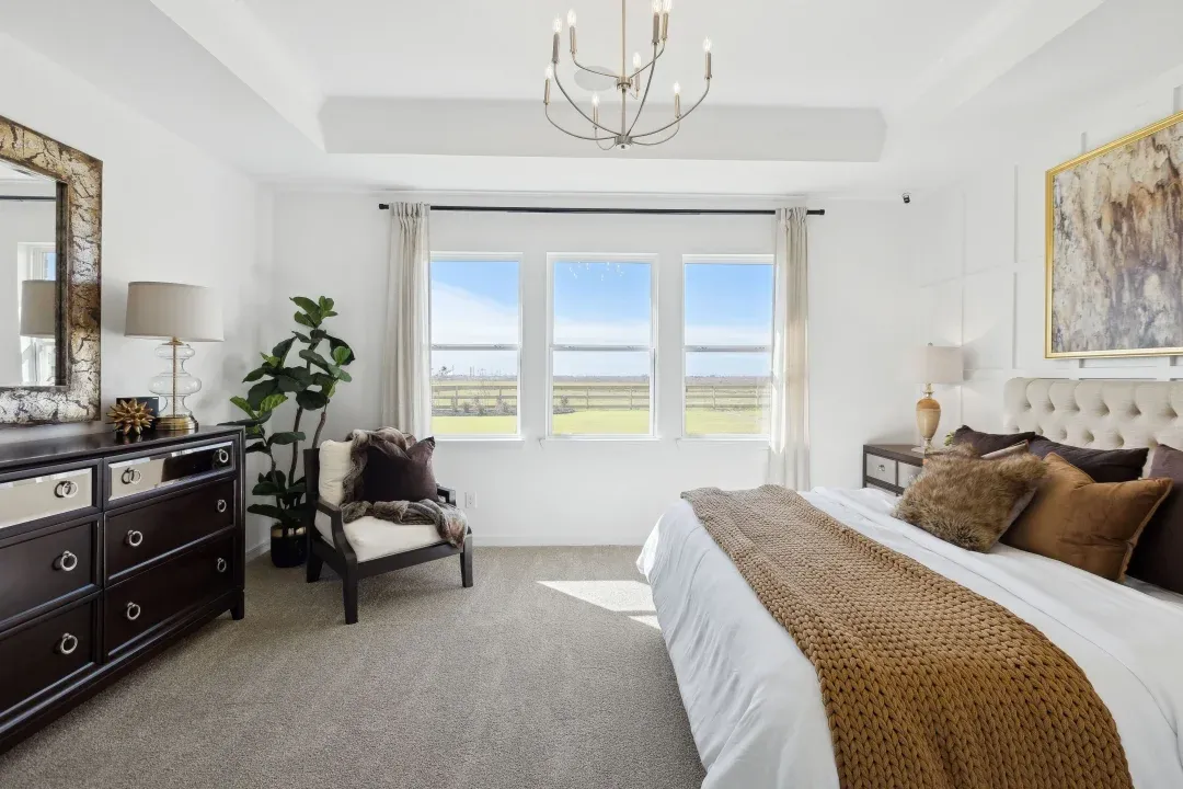 Primary suite with chandelier and tray ceiling