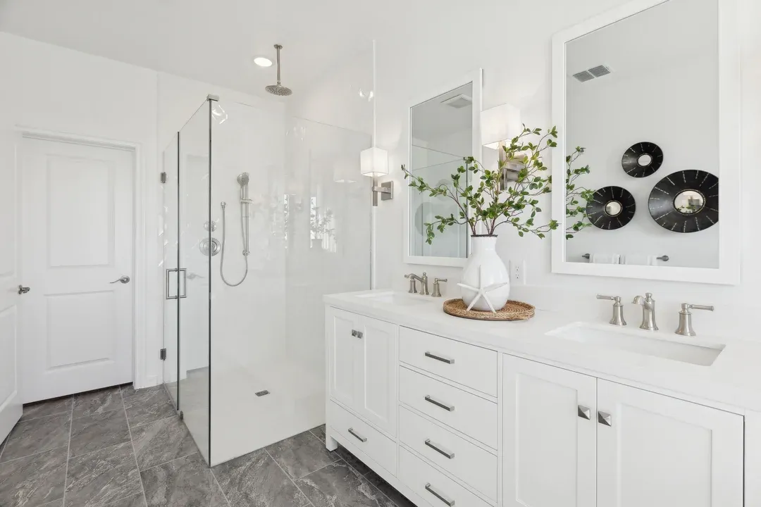 Primary bath with glass shower enclosure and freestanding vanity