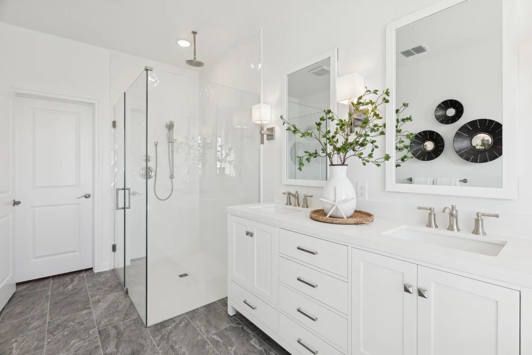 Primary bath with glass shower enclosure and freestanding vanity
