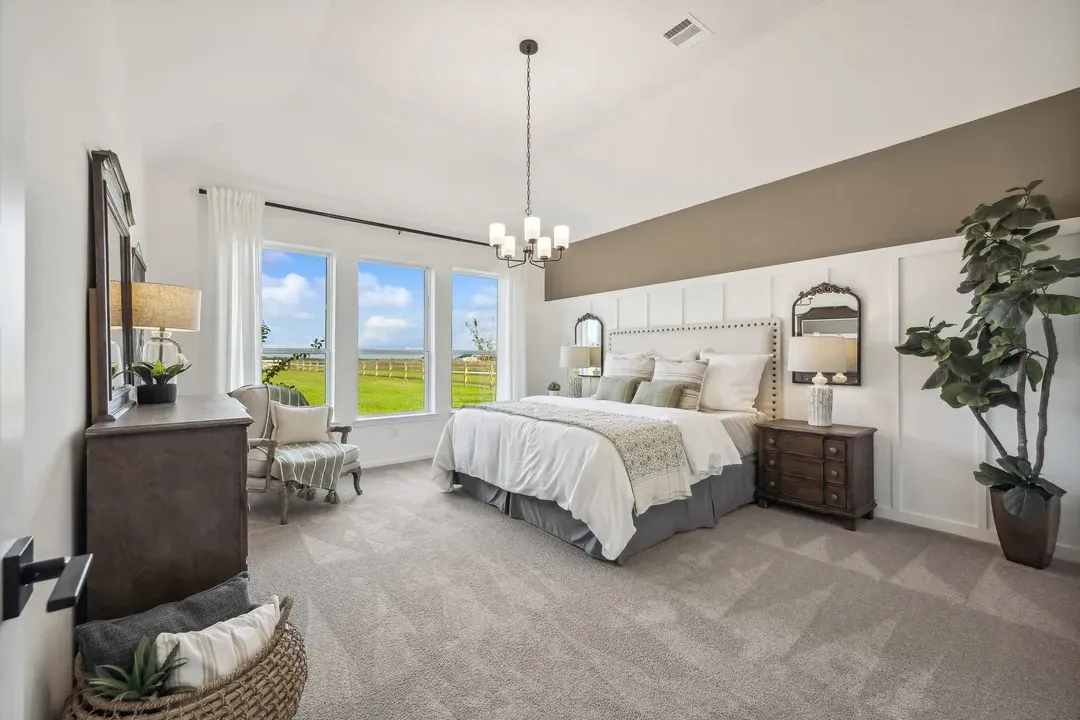 Primary suite with sloped ceiling and decorative feature wall