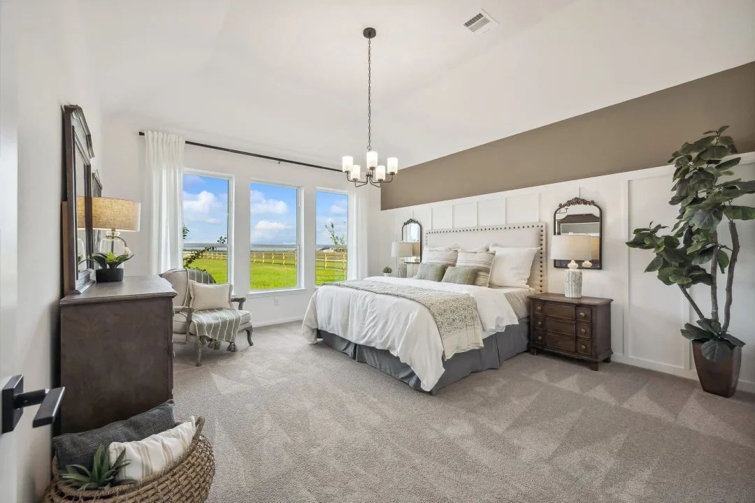 Primary suite with sloped ceiling and decorative feature wall