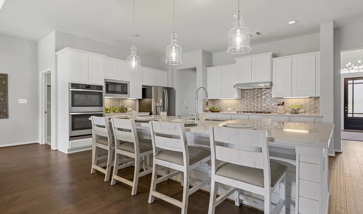 Kitchen with wall oven and sleek pendant lighting