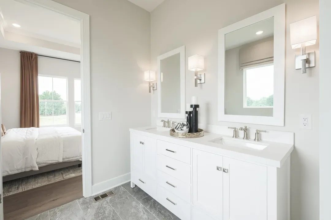 Private primary bath features freestanding vanity with dual sinks