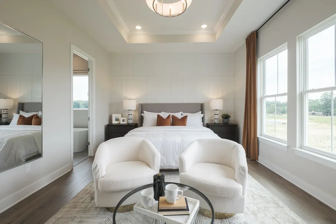 Primary suite with elegant ceiling treatment and decorative feature wall