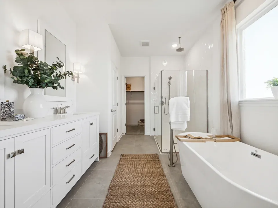 Primary bath with freestanding soaking tub, dual sinks, and glass shower enclosure