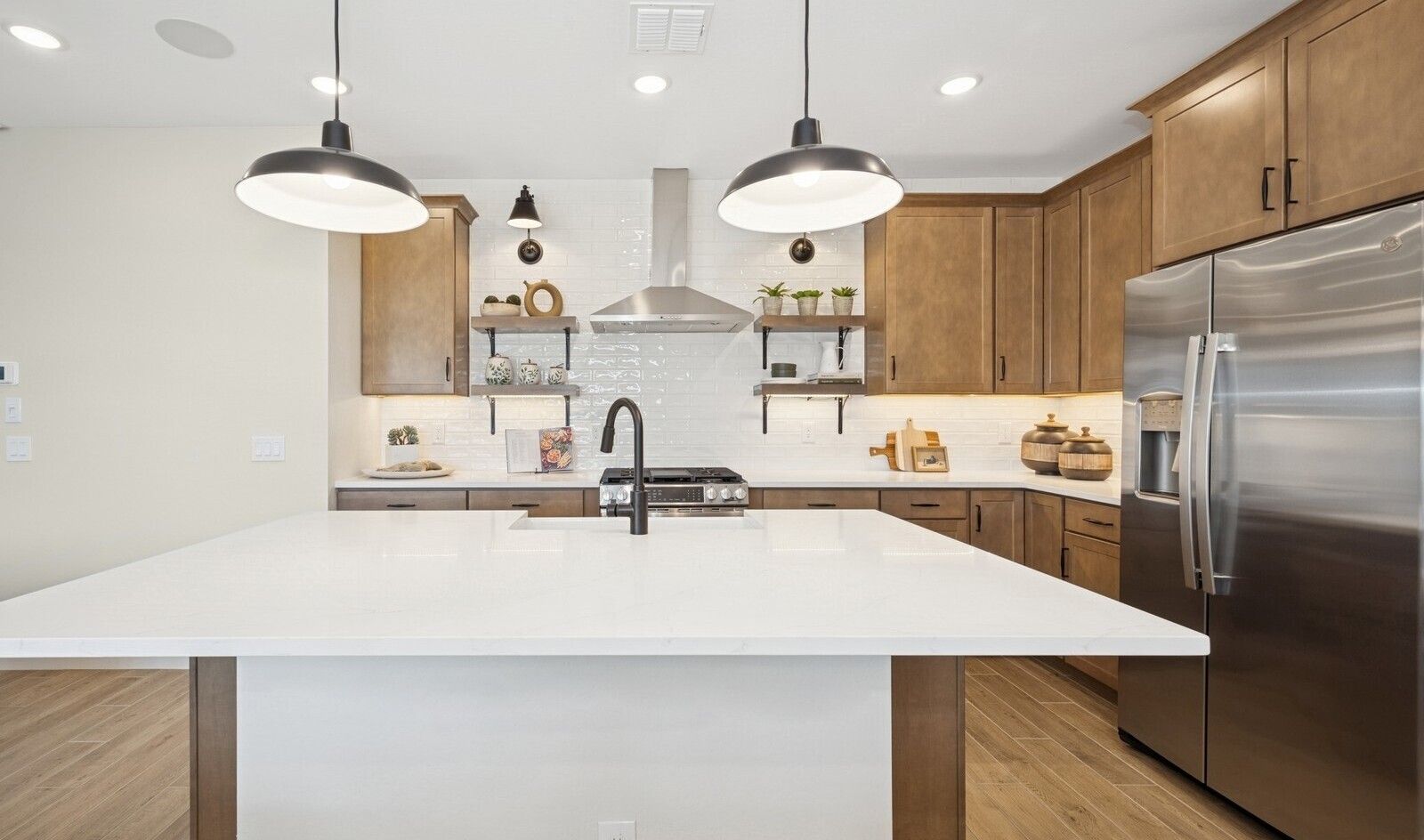 Kitchen with floating shelves and stainless steel hood