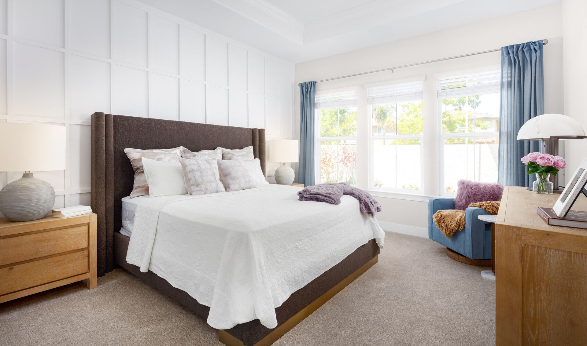 Primary suite with decorative feature wall and coffered ceiling