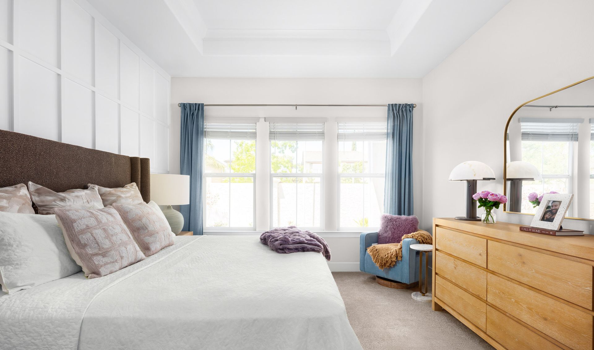 Primary suite with plush carpeting and decorative feature wall