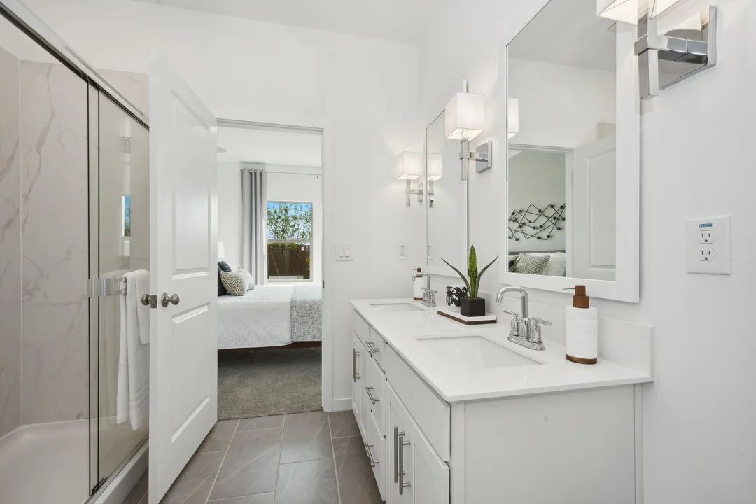 Primary bath with glass shower enclosure and sconce lighting