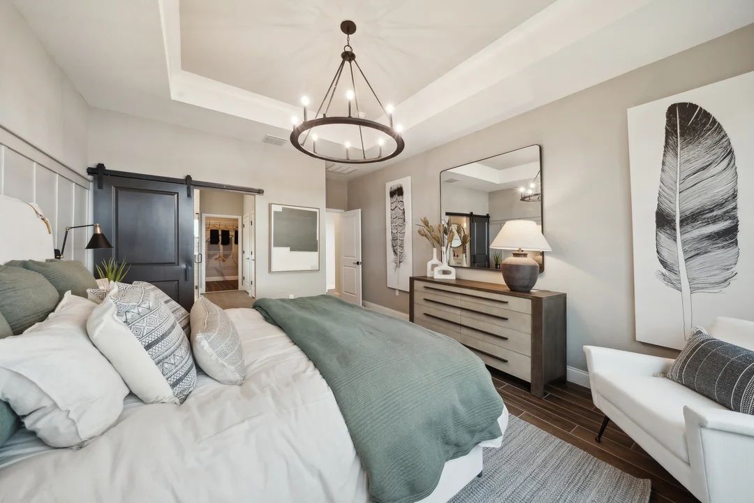 Primary suite with tray ceiling and decorative feature wall