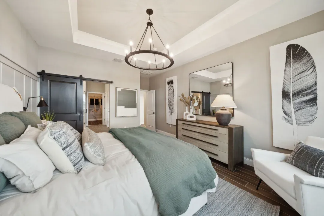 Primary suite with tray ceiling and decorative feature wall
