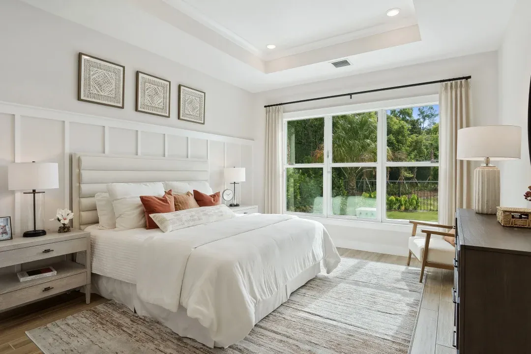 Primary suite with tray ceiling and decorative feature wall