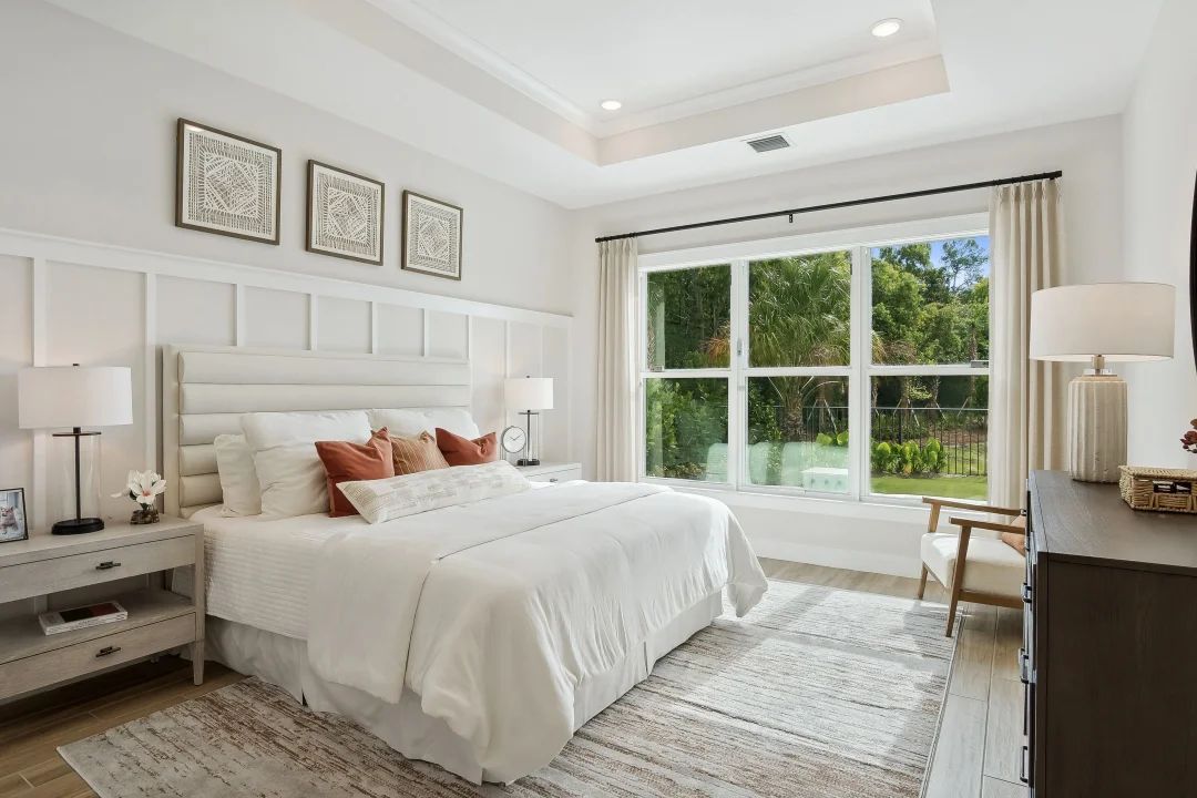 Primary suite with tray ceiling and decorative feature wall