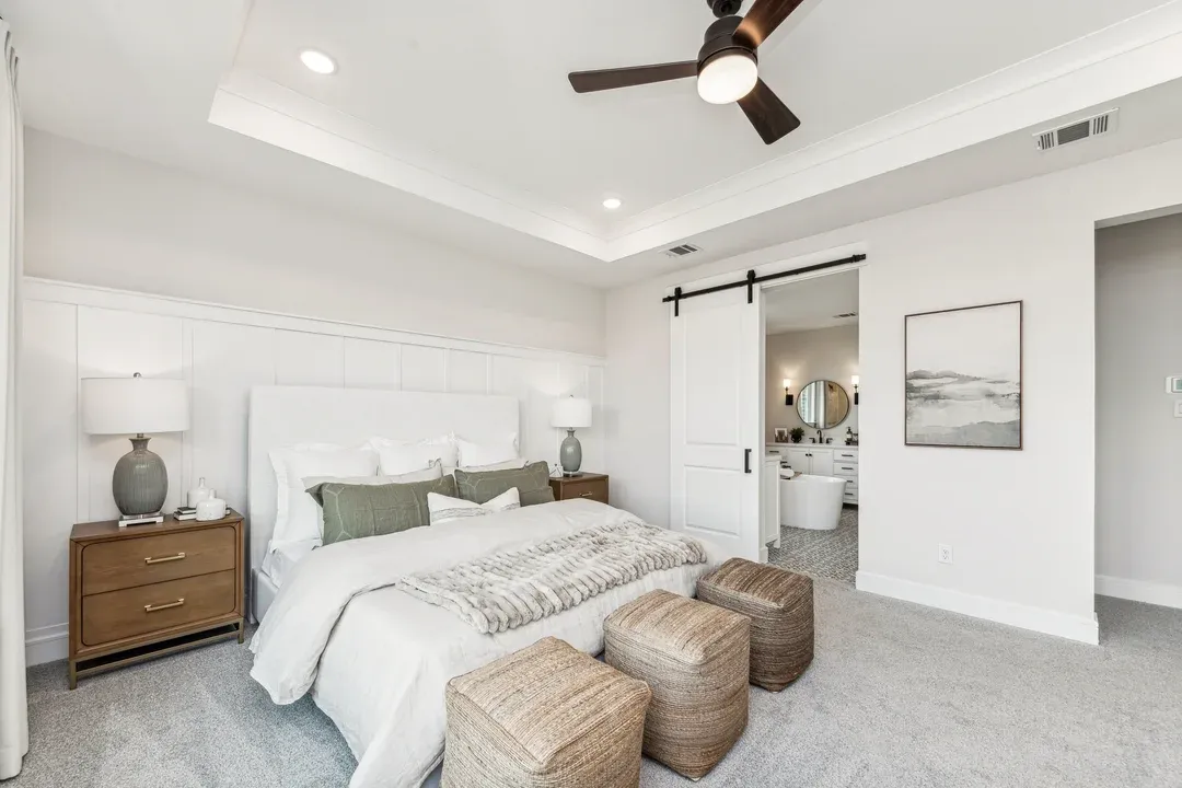 Primary suite with tray ceiling and decorative feature wall