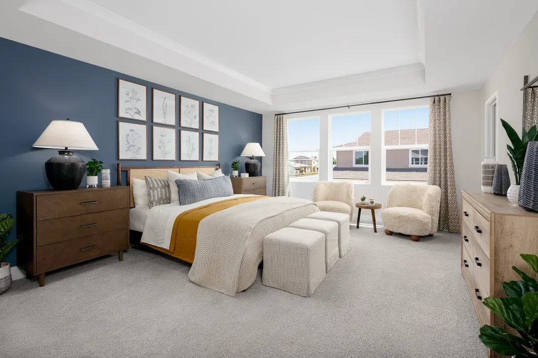 Primary suite with crown moulding and plush carpeting