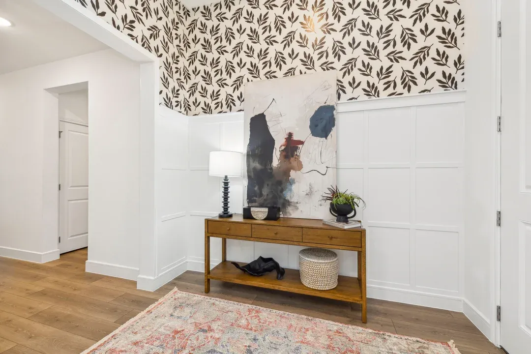Foyer with decorative feature wall and wide-plank flooring