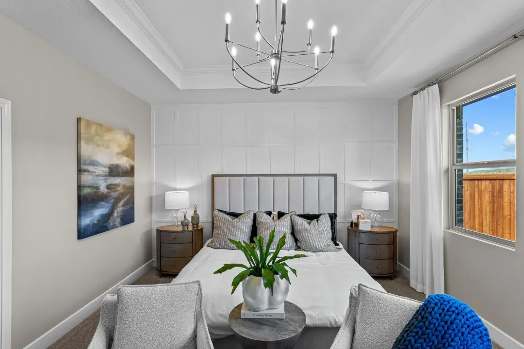 Primary suite with tray ceiling and decorative feature wall