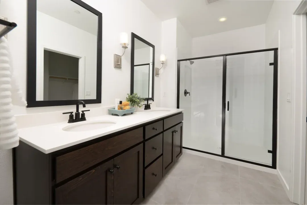 Primary bath with dual sinks and glass shower enclosure