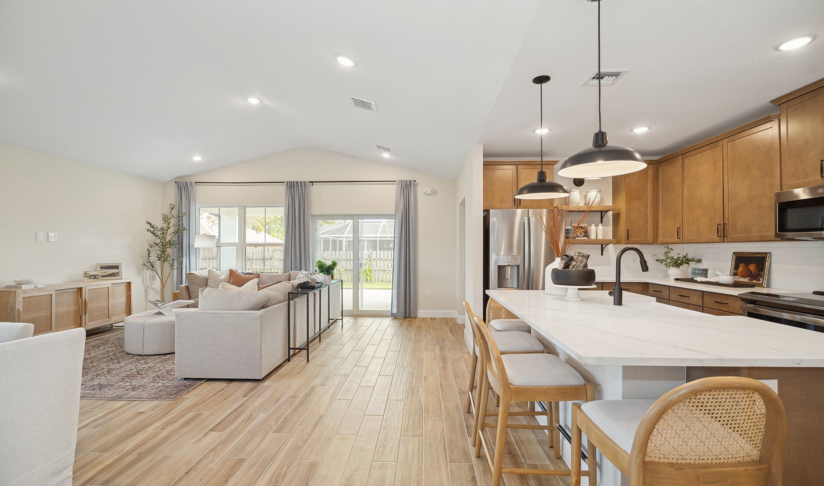 Kitchen overlooking great room and dining area with vaulted ceiling