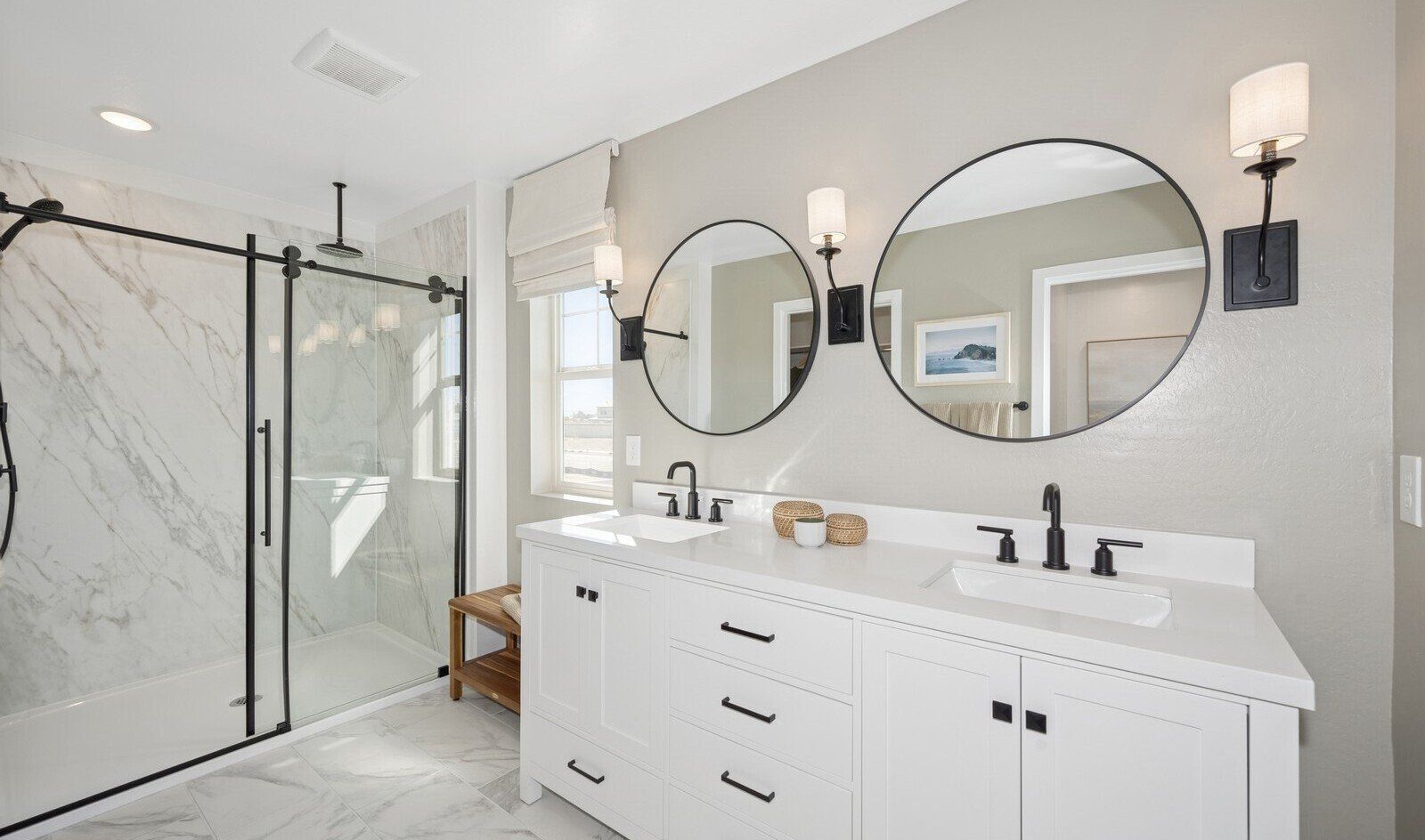 Primary bath with dual circular mirrors and matte black fixtures