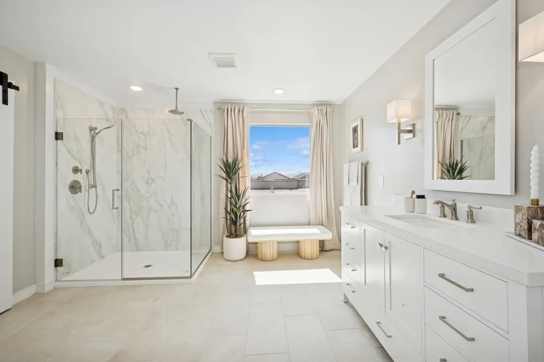 Primary bath with freestanding vanity and glass shower enclosure