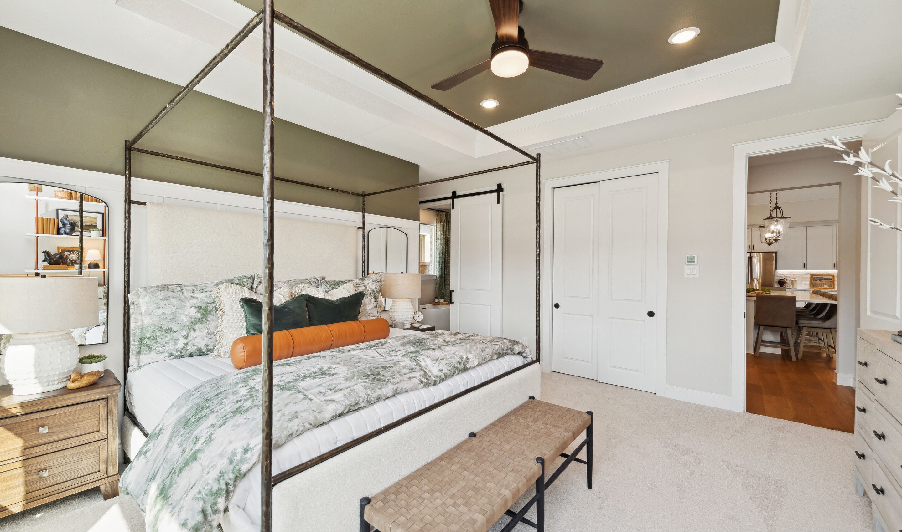 Primary suite with feature wall, tray ceiling and barn door to bath