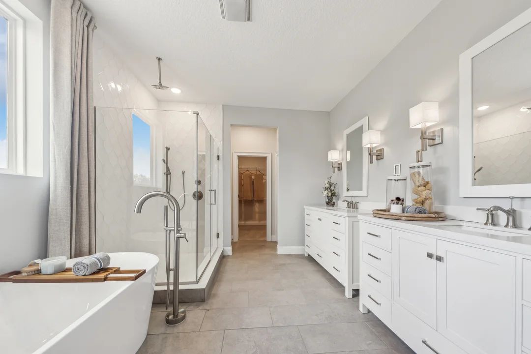 Primary bath with freestanding vanities and tub