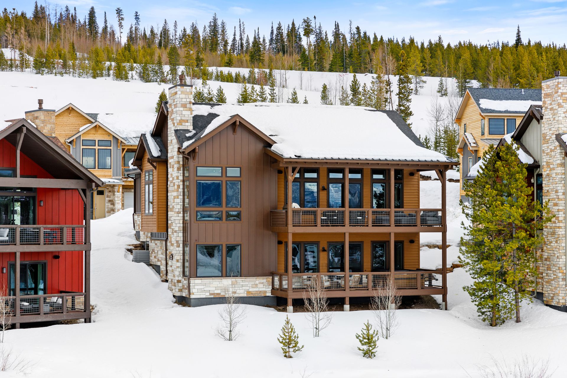 The Hummingbird offers 3 bedrooms and 3.5 baths with an optional 4th bedroom. Two family rooms and two primary suites provide flexible living, while upper and lower decks embrace the beauty of mountain living.