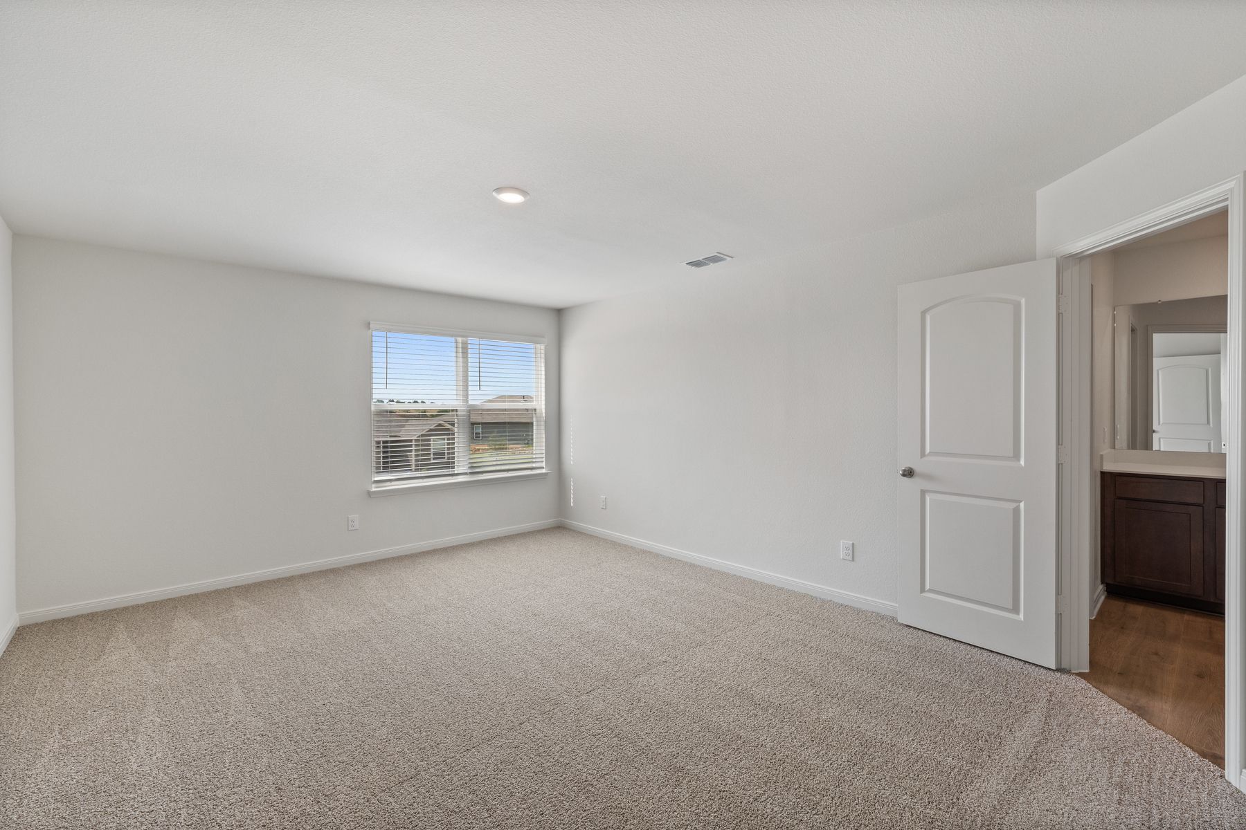 The spacious master bedroom has a large window that lets in natural light and backyard views.
