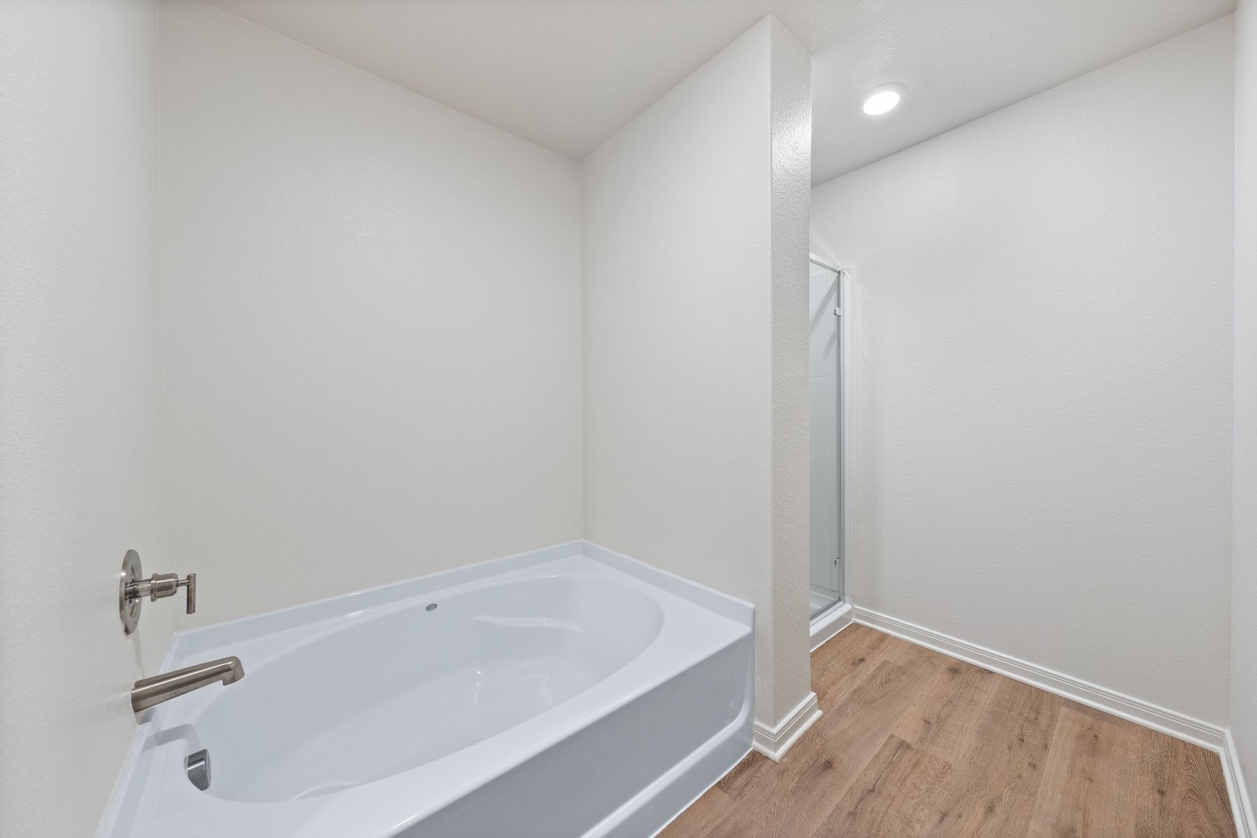 The master bathroom has a large garden tub and glass, walk-in shower.
