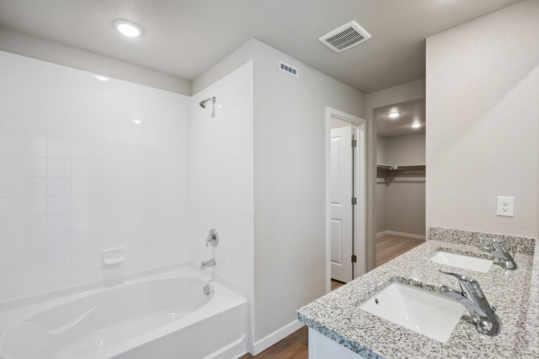 The master bathroom has a dual sink vanity, a step in shower and a soaking tub.