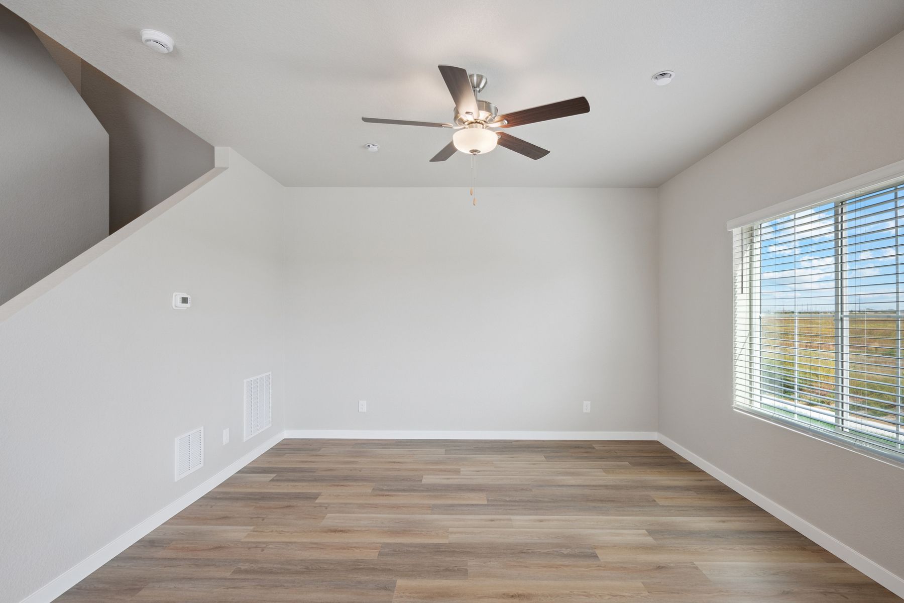 The family room is spacious with a ceiling fan.