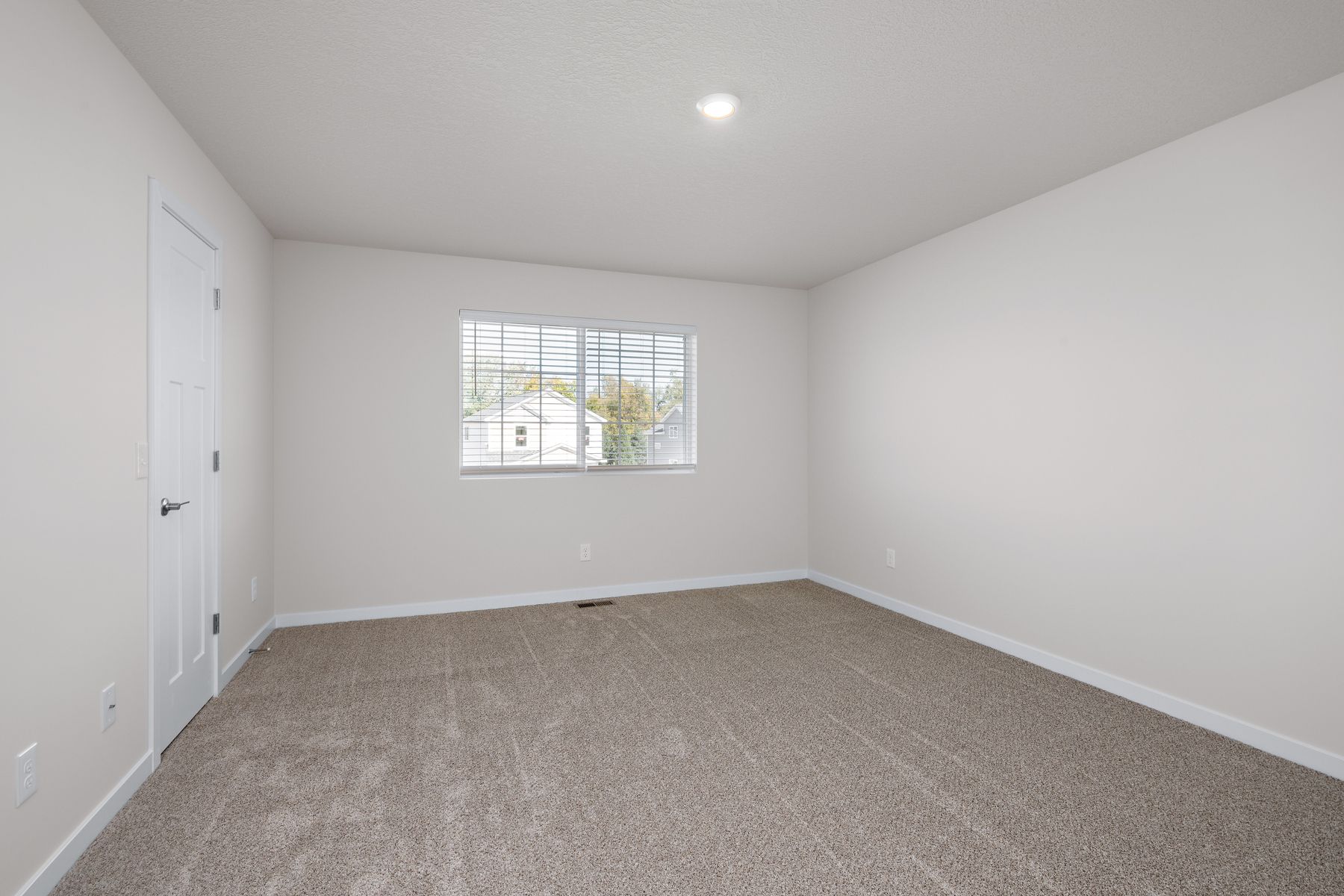 The master bedroom is spacious and has carpet.