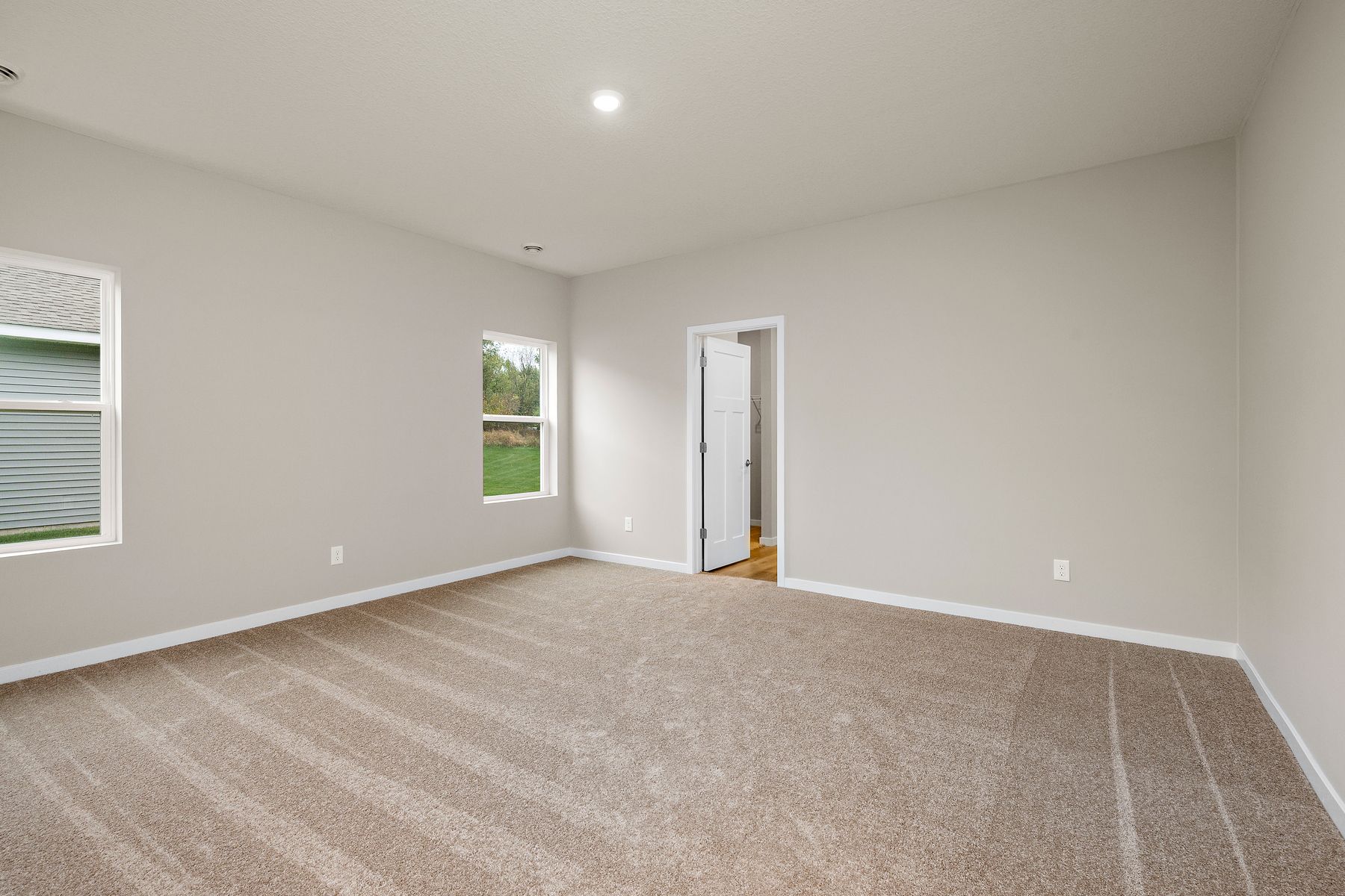 The master bedroom is spacious and has carpet.
