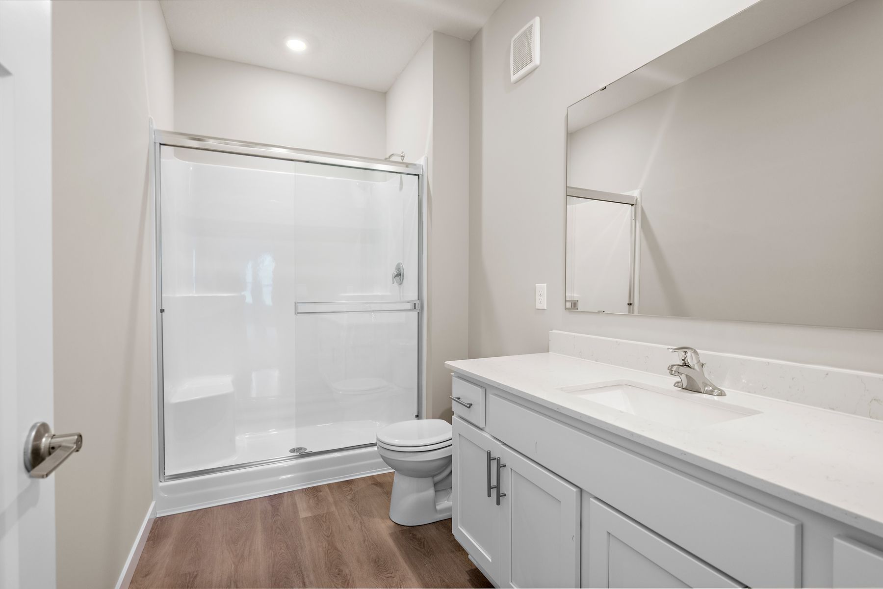 The master bathroom has a large vanity and a step in shower,