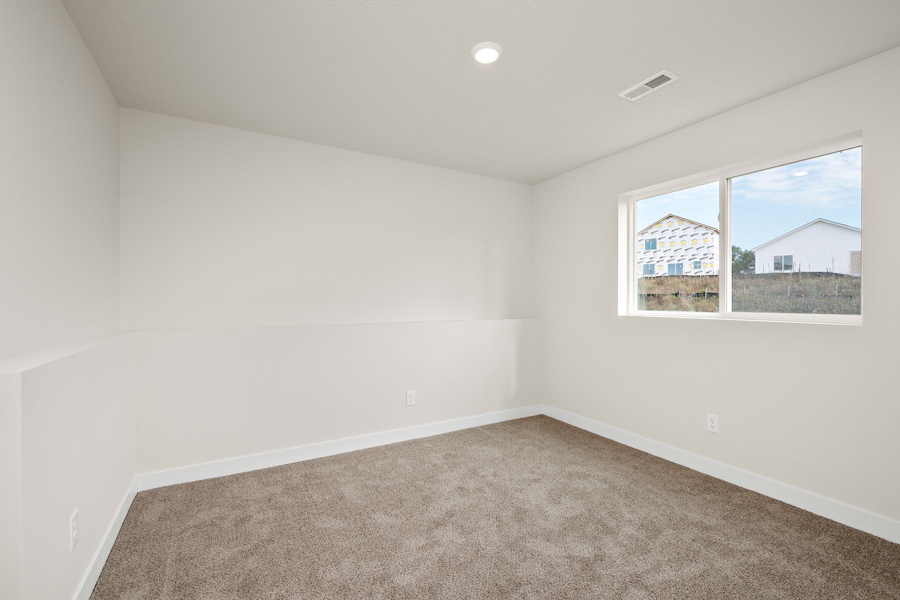 The master bedroom is spacious and has carpet.
