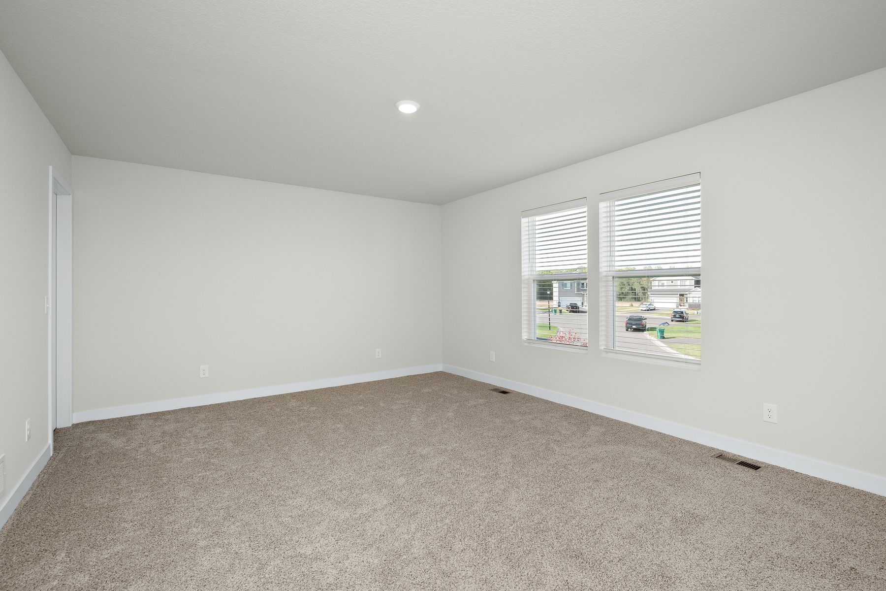 The master bedroom is spacious and has carpet.