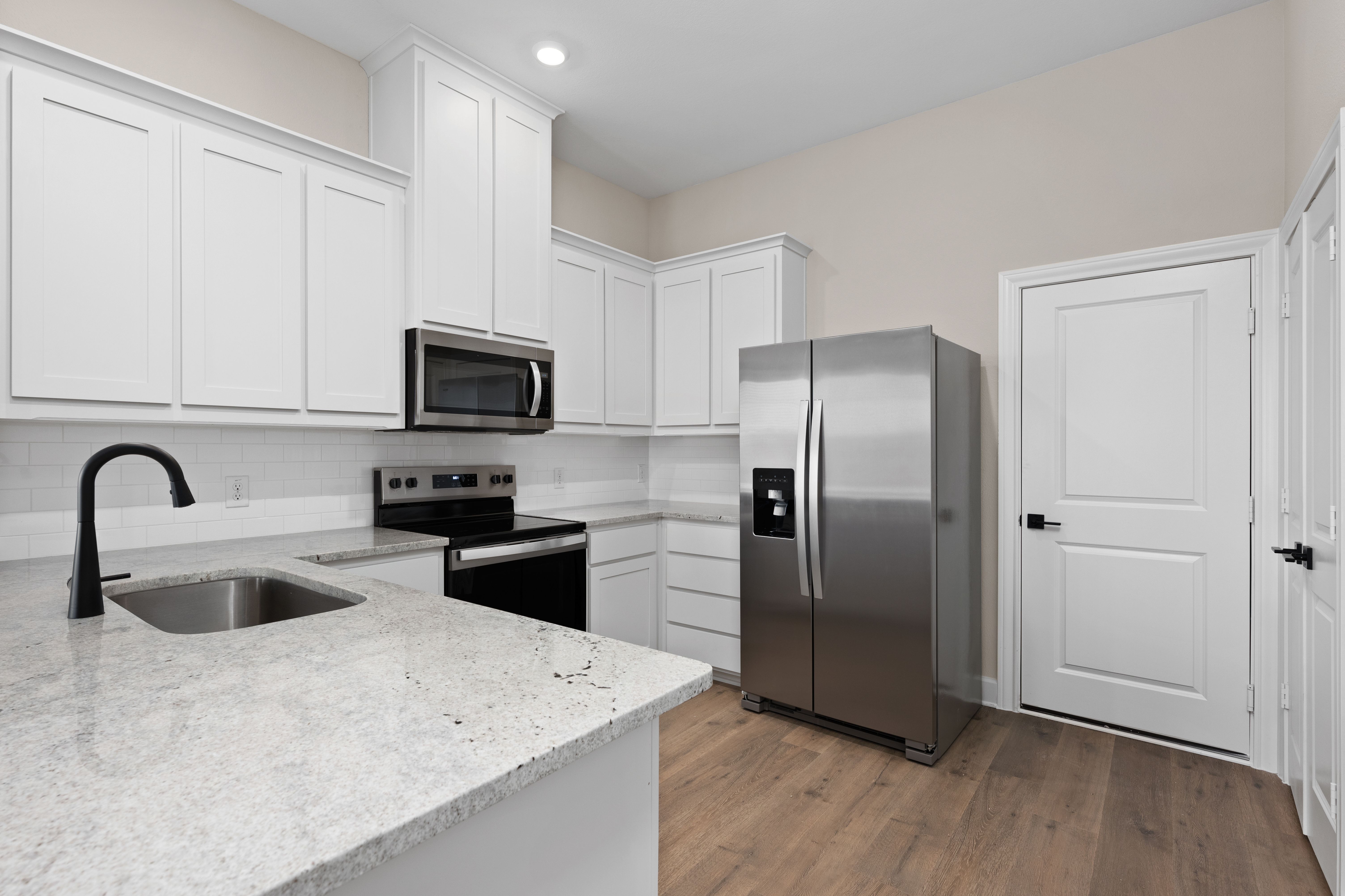 The kitchen has beautiful white wood cabinetry.