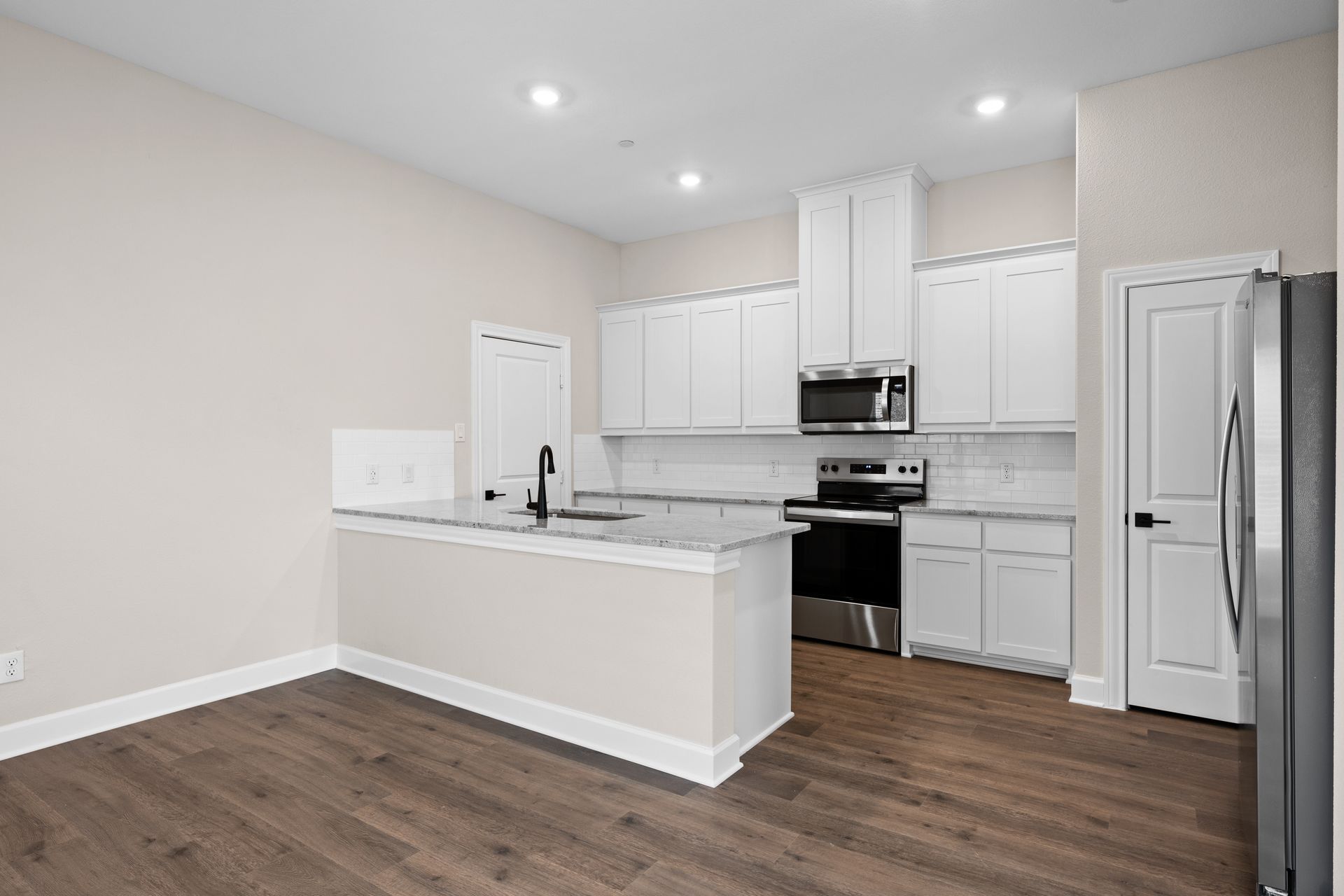 The kitchen has beautiful white wood cabinetry.