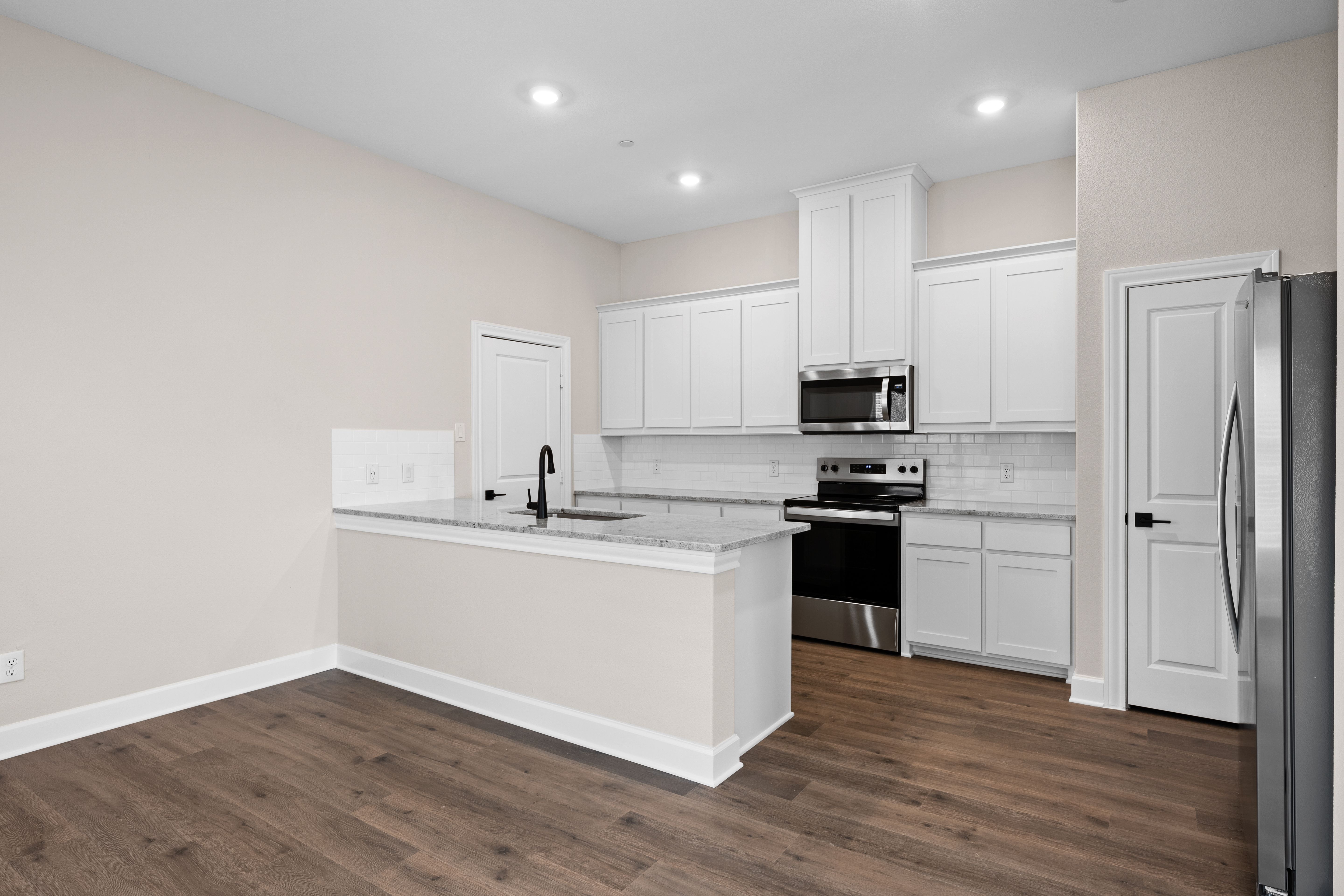 The kitchen has beautiful white wood cabinetry.