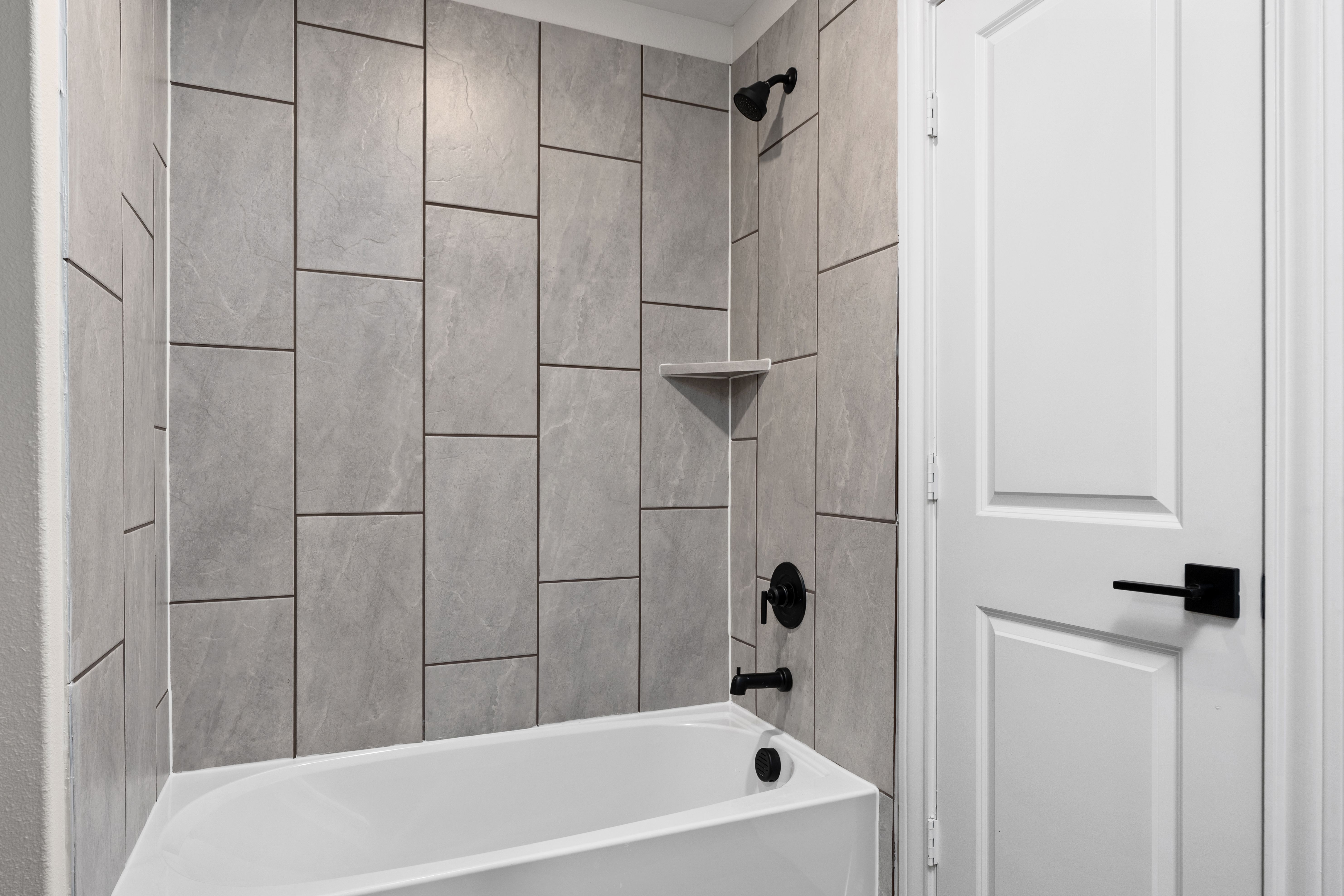 The secondary bathroom has a tiled, shower-tub combo.