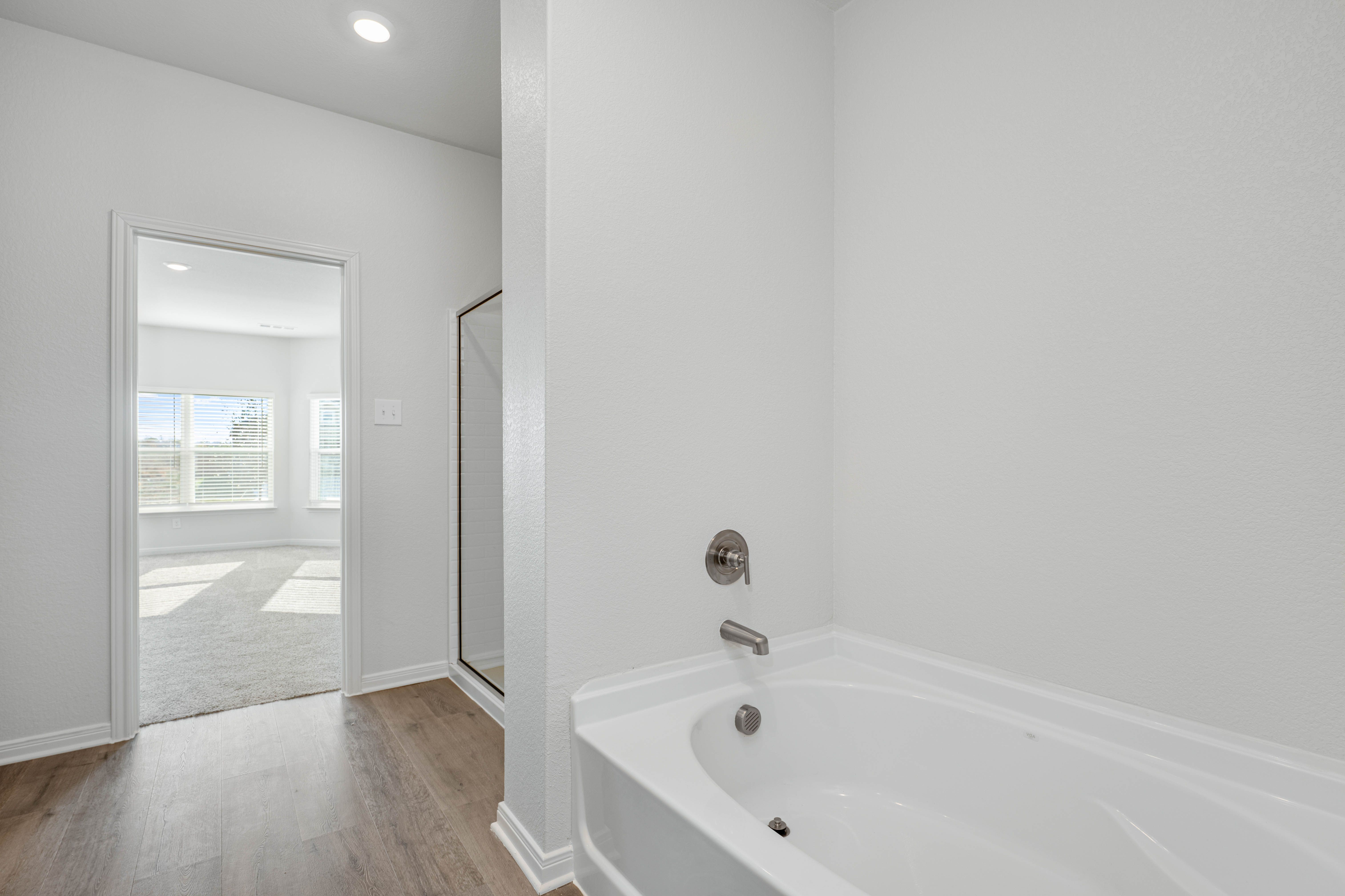 The master bathroom has a glass, walk-in shower and a garden tub.