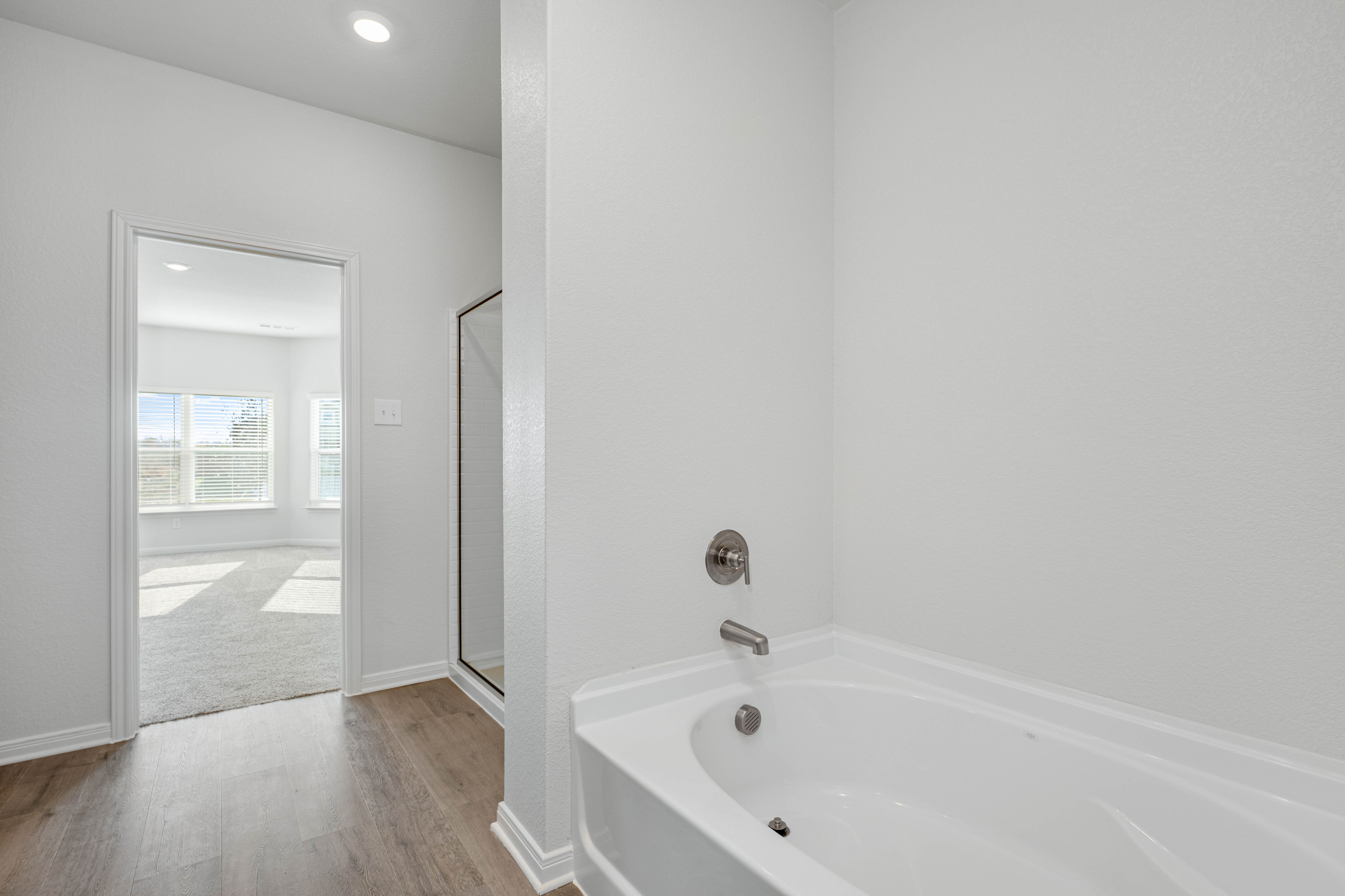 The master bathroom has a glass, walk-in shower and a garden tub.