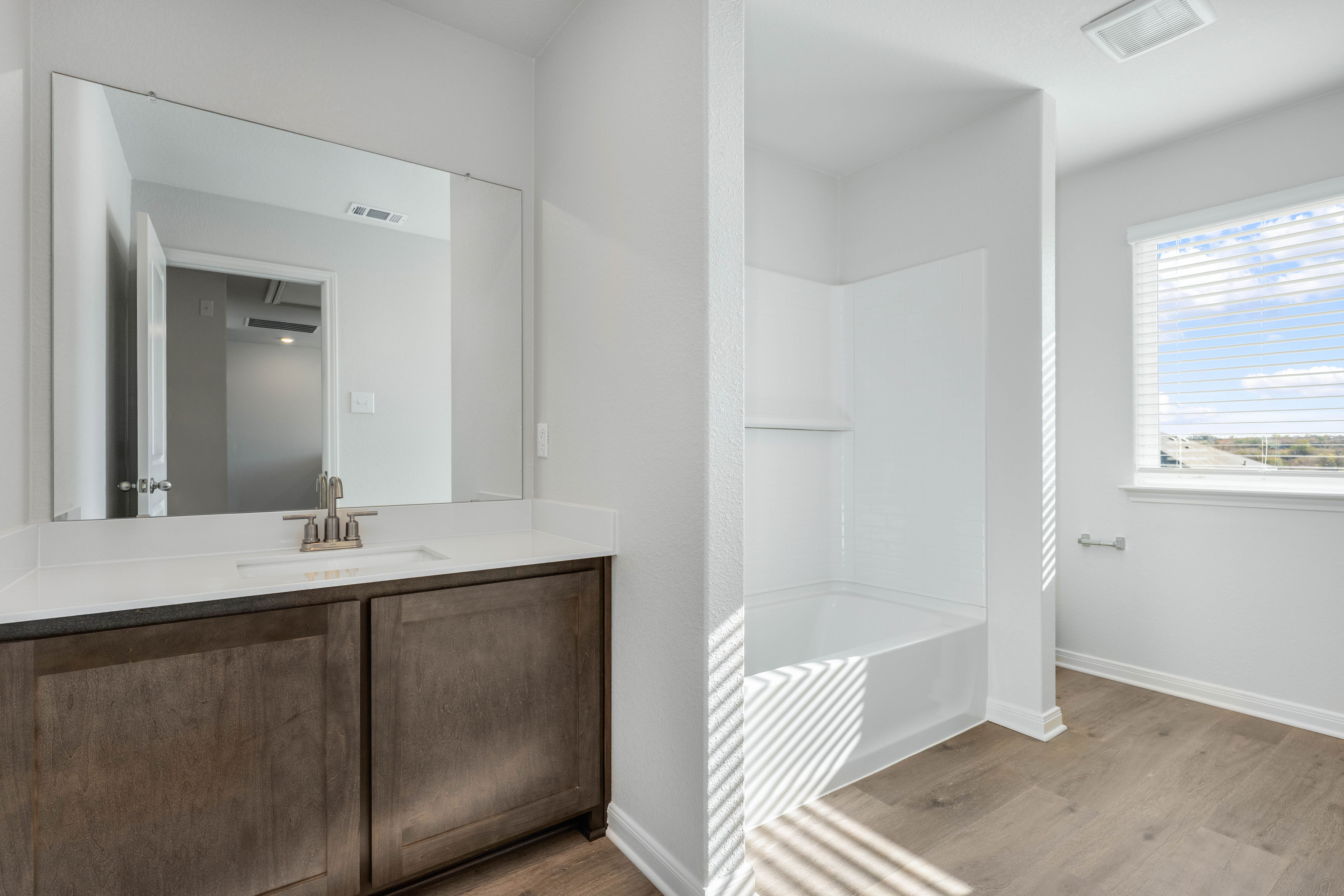 The secondary bathroom has a sprawling vanity and a shower-tub combo.